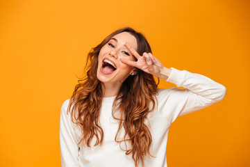 Happy young woman showing peace gesture