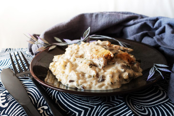 Tasty risotto with chicken, fresh herbs vegetables on a white plate