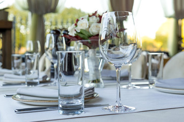 glass glasses on the table, festive table setting, tableware, flower bouquet