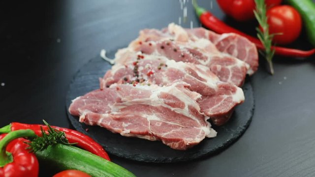 raw beef steak and salt by chef. modern design delicious dish training cooking master menu restaurant food fresh vegetables meat black background spices hot chilli pepper unique recipe ingredients