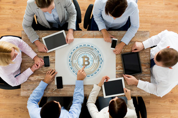 business team with bitcoin holgram at table