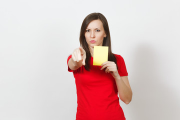 European serious severe young woman, football referee in red uniform show yellow soccer card,...