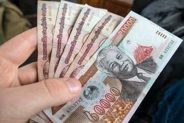Mans hand holding Laos money, kip banknotes close up