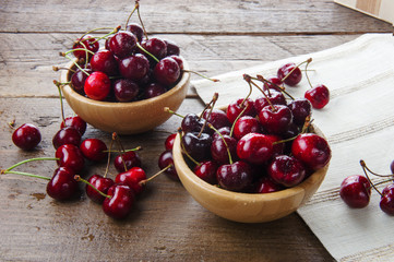 Two wooden bowls of delicious cherries