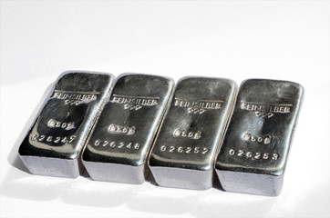 Four cast silver bars isolated on white background. Selective focus. feinsilber is a fine silver..