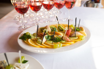 Plate with lots of healthy sliced fruits: oranges, apples, kiwi with sugar powder. Fruits