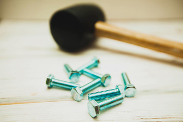 Repair carpenter tools: rubber hummer and screws on white old wooden background, top view, copy space
