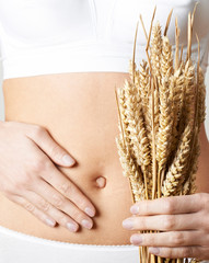Close Up Of Woman Wearing Underwear Holding Bundle Of Wheat And Touching Stomach