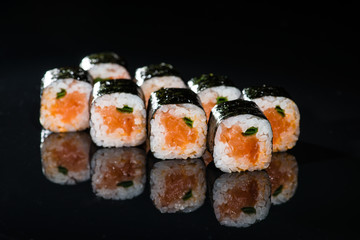 Fresh delicious Japanese sushi with salmon on dark background
