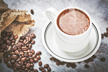 Coffee cup and coffee beans on table