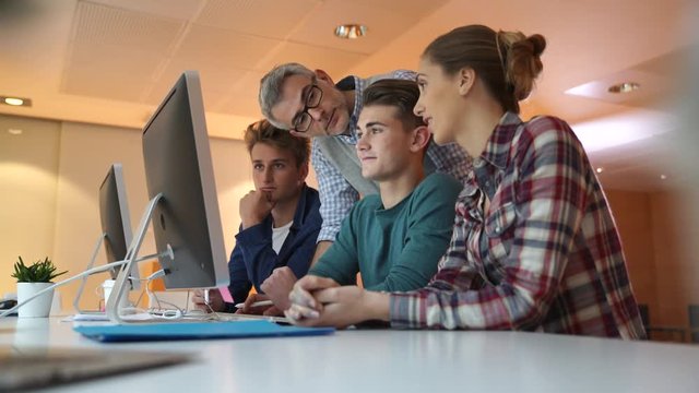 Group of students in computing class with teacher