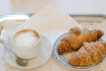 Cup of cappuccino coffee and croissant - italian breakfast