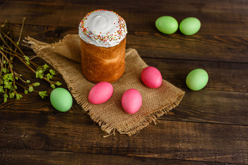 Easter cake and colorful eggs on a wooden table. It can be used as a background