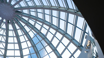 Glass dome of a modern building. View from the inside of the room. Light construction of transparent roof made of round steel tubes. Architectural background. Glass dome from inside at skyscrapper