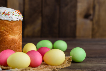 Easter cake and colorful eggs on a wooden table. It can be used as a background