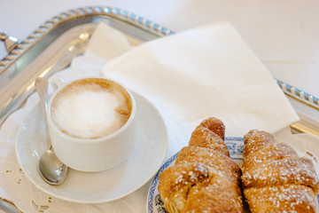 Cappuccino and croissant on a tray - italian breakfast