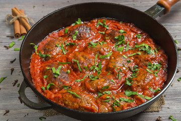 Greek soutzoukakia the patties in tomato sauce in the pan. 