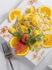 Mango Salad Indian food dish with fresh cut oranges plated with fork photographed from overhead above view