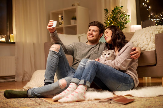 happy couple taking selfie by smartphone at home