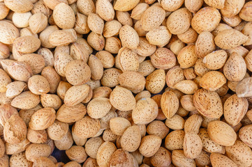 group of almond nuts in peel, natural food background