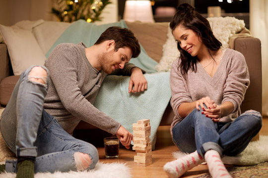 happy couple playing block-stacking game at home