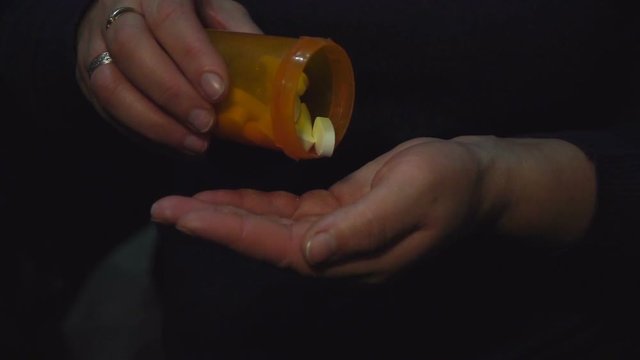 Woman taking pills. Slow motion video