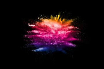 Multicolored powder explosion cloud isolated on black background. Freeze motion of color dust  particles splash.