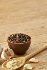 Composition of powder spices on spoon and different sorts of spicies on wooden table background, selective focus