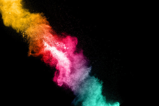 Multicolored powder explosion cloud isolated on black background. Freeze motion of color dust  particles splash.