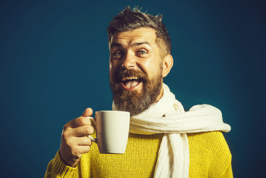 Season, drinks and people concept - happy smiling young man with cup drinking hot tea in winter.
