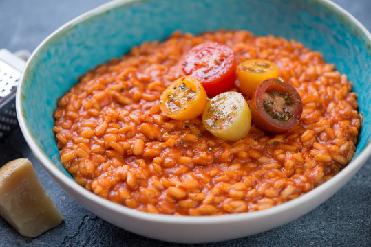 Close-up of a blue bowl with tomato risotto, selective focus, horizontal shot