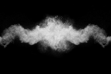 Launched white particle splash on black background. Bizarre forms of of white powder explosion cloud against dark background.