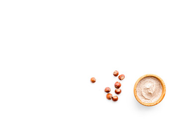 Natural cosmetics for skin care. Body scrub with hazelnut. White background top view copy space