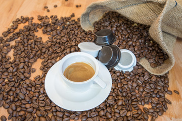 Caffè espresso in tazzina e capsule con chicchi di caffè
