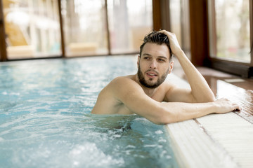 Handsome young man relaxing in the pool