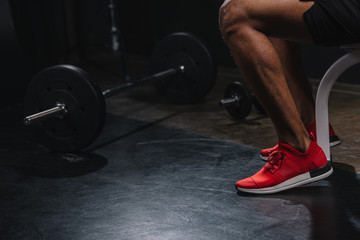 Fototapeta na wymiar cropped shot of african american sportsman in sneakers training in gym
