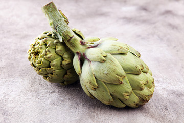 Fototapeta premium artichokes on grey background. fresh organic artichoke flower.