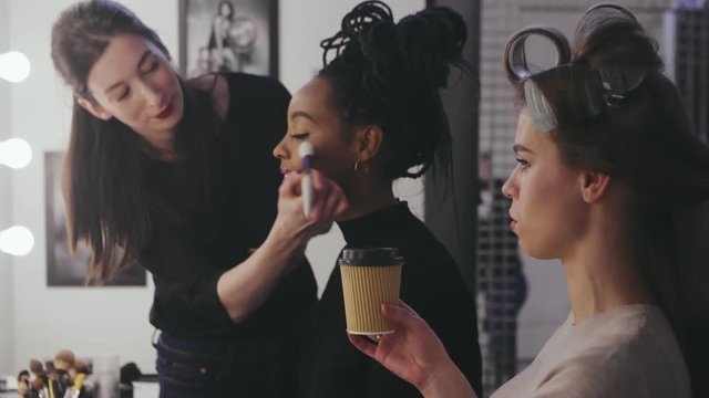 Beauty models talking during preparation in dressing room fashion show