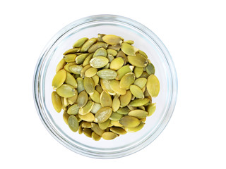Pumpkin seeds in glass bowl isolated on white background