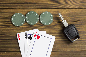 Cards, chips and car key, wooden background