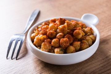 Fried spicy chickpeas on wooden table