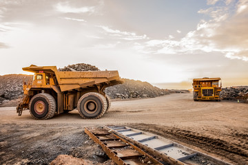 Fototapeta Mining dump trucks transporting Platinum ore for processing obraz