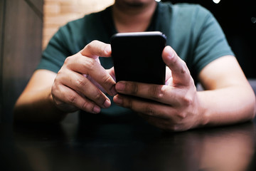 Cropped view of male hands holding cell phone with blank screen.Man using electronic gadget, typing message or checking newsfeed on social networks.