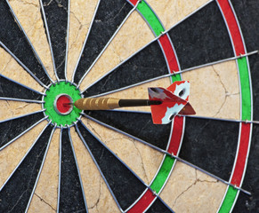 Dart board with a dart in the bullseye.