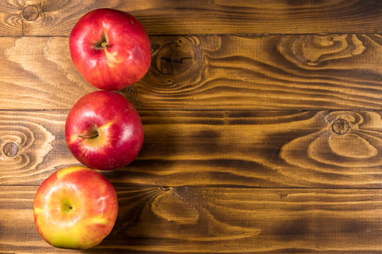 Red apples on wooden table. Top view, copy space