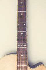 Wooden acoustic guitar against a plain background