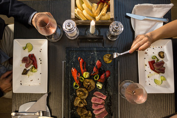 Man and woman eating during candlelight lunch.Overhead top view straight-down perspective.Couple in love romantic dinner at restaurant