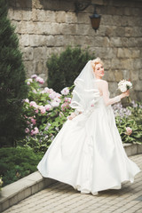 Obraz premium Portrait of stunning bride with long hair posing with great bouquet