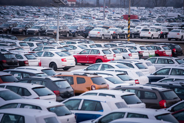 Many new cars parked in a row, ready for export