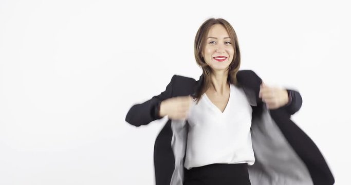 Young business woman puts on a black jacket, straightens hair and smile looking at camera.
